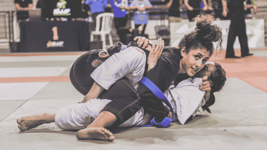 Mulheres treinando jiu-jitsu com intensidade em academia moderna
