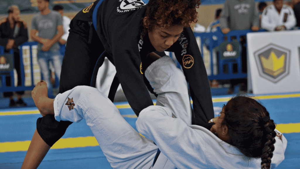 Lutadora de jiu-jitsu ajoelhada no tatame respirando fundo antes de rolar